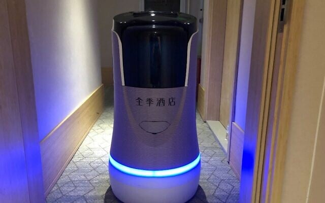 This photo taken on April 28, 2020, shows a robot capable of taking elevators and navigating hallways on its own delivering food to a guest at a quarantine hotel housing people from Hubei province in Beijing (Jing Xuan TENG / AFP) This photo taken on April 28, 2020, shows a robot capable of taking elevators and navigating hallways on its own delivering food to a guest at a quarantine hotel housing people from Hubei province in Beijing (Jing Xuan TENG / AFP)