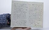 An archivist at the National Library of Israel displays a letter dated 1900 by Oxford English Dictionary editor James Murray, at the library in Jerusalem on February 27, 2020. (Menahem Kahana/AFP)