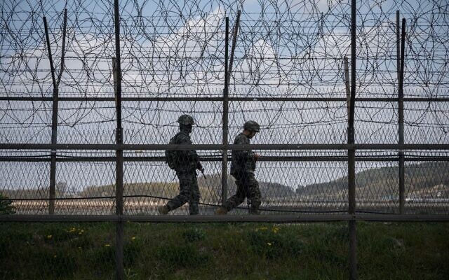 This file photo taken on April 23, 2020, shows South Korean soldiers patrolling along a barbed wire fence at the Demilitarized Zone (DMZ) separating North and South Korea, on the South Korean island of Ganghwa. (Photo by Ed JONES / AFP) This file photo taken on April 23, 2020, shows South Korean soldiers patrolling along a barbed wire fence at the Demilitarized Zone (DMZ) separating North and South Korea, on the South Korean island of Ganghwa. (Photo by Ed JONES / AFP)