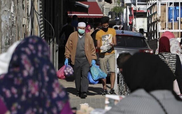 Palestinians shop while wearing protective masks amid the ongoing coronavirus pandemic in the West Bank city of Ramallah, on May 7, 2020. (Abbas Momani/AFP) Palestinians shop while wearing protective masks amid the ongoing coronavirus pandemic in the West Bank city of Ramallah, on May 7, 2020. (Abbas Momani/AFP)