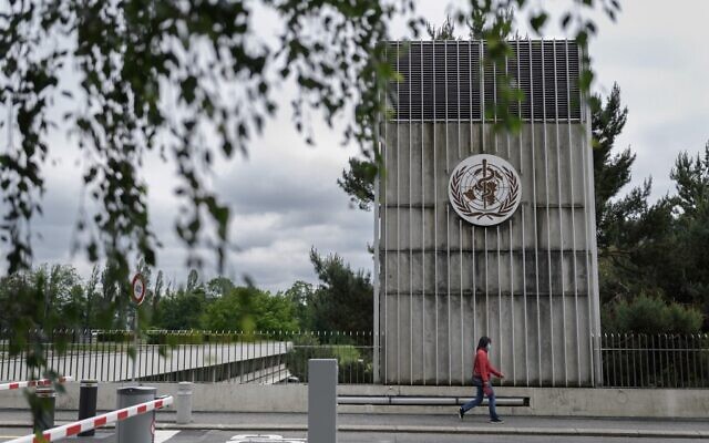 A woman wearing a protective facemask walks underneath a sign at the World Health Organization (WHO) headquarters in Geneva, Switzerland, May 12, 2020. (Fabrice Coffrini/AFP) A woman wearing a protective facemask walks underneath a sign at the World Health Organization (WHO) headquarters in Geneva, Switzerland, May 12, 2020. (Fabrice Coffrini/AFP)