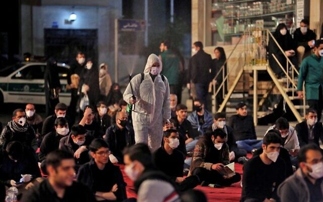Iranians, some wearing face masks against the coronavirus, attend Laylat al-Qadr prayers, one of the holiest nights during the Muslim fasting month of Ramadan, outside a mosque in the Tehran, on May 13, 2020. (Photo by ATTA KENARE / AFP) Iranians, some wearing face masks against the coronavirus, attend Laylat al-Qadr prayers, one of the holiest nights during the Muslim fasting month of Ramadan, outside a mosque in the Tehran, on May 13, 2020. (Photo by ATTA KENARE / AFP)