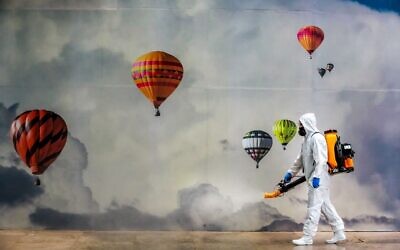 An employee wearing protective gear disinfects a shopping mall as a preventive measure against the COVID-19 coronavirus in Caxias do Sul, Brazil on May 13, 2020. (SILVIO AVILA / AFP) An employee wearing protective gear disinfects a shopping mall as a preventive measure against the COVID-19 coronavirus in Caxias do Sul, Brazil on May 13, 2020. (SILVIO AVILA / AFP)