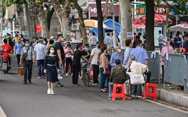 People wearing face masks wait in line to be tested for COVID-19 on a street in Wuhan, in China's central Hubei province, May 16, 2020. (Hector RETAMAL / AFP) People wearing face masks wait in line to be tested for COVID-19 on a street in Wuhan, in China's central Hubei province, May 16, 2020. (Hector RETAMAL / AFP)
