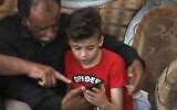 Hussein Dawabsha (L) sits with his grandson Ahmad, the survivor of the arson attack that killed his parents and 18-month-old brother, in the West Bank village of Duma on May 18, 2020. (JAAFAR ASHTIYEH / AFP)
