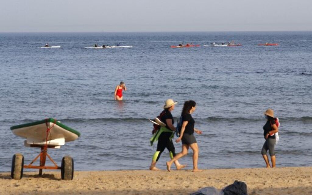 Beach-goers walk at a beach in the coastal city of Tel Aviv on May 20, 2020, as beaches open for the first time after two months of confinement due to the COVID-19 coronavirus pandemic. (Jack Guez/AFP) Beach-goers walk at a beach in the coastal city of Tel Aviv on May 20, 2020, as beaches open for the first time after two months of confinement due to the COVID-19 coronavirus pandemic. (Jack Guez/AFP)
