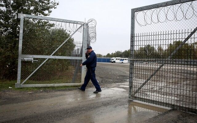 Illustrative: A Hungarian policeman closes a razor wire fence at a migrant transit center near Roszke, at the border crossing with Serbia, October 29, 2019. (Oliver Bunic/AFP) Illustrative: A Hungarian policeman closes a razor wire fence at a migrant transit center near Roszke, at the border crossing with Serbia, October 29, 2019. (Oliver Bunic/AFP)