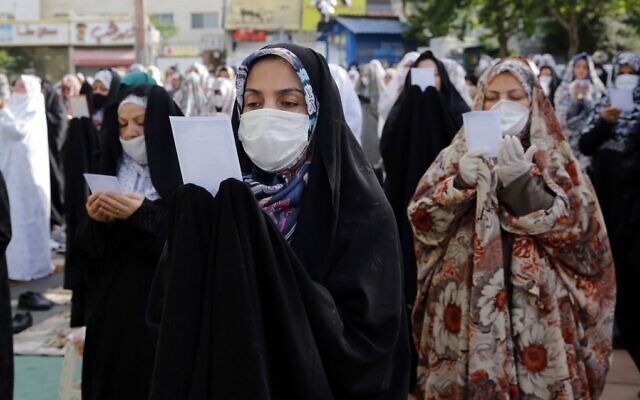 Muslim women worshipers, standing spaced from each other with some clad in masks as a measure against the COVID-19 coronavirus pandemic, as they gather to attend the prayers of Eid al-Fitr, the Muslim holiday which starts at the conclusion of the holy fasting month of Ramadan, in Iran's capital Tehran on May 24, 2020 (STRINGER / AFP)