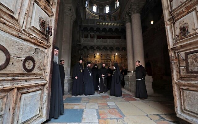 Greek Orthodox, Coptic Orthodox, Armenian, and Franciscan clergymen stand inside the Church of the Holy Sepulchre in Jerusalem's Old City on May 24, 2020, (GALI TIBBON/AFP) Greek Orthodox, Coptic Orthodox, Armenian, and Franciscan clergymen stand inside the Church of the Holy Sepulchre in Jerusalem's Old City on May 24, 2020, (GALI TIBBON/AFP)