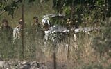 Israeli soldiers inspect a car at the scene of an apparent attempted car-ramming attack near the West Bank settlement of Halamish on May 29, 2020. (Abbas Momani/AFP)