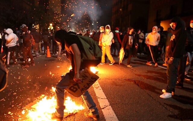 A demonstrator tried to extinguish a trash fire during a protest sparked by the death of George Floyd while in police custody on May 29, 2020 in Oakland, California (Justin Sullivan/Getty Images/AFP)