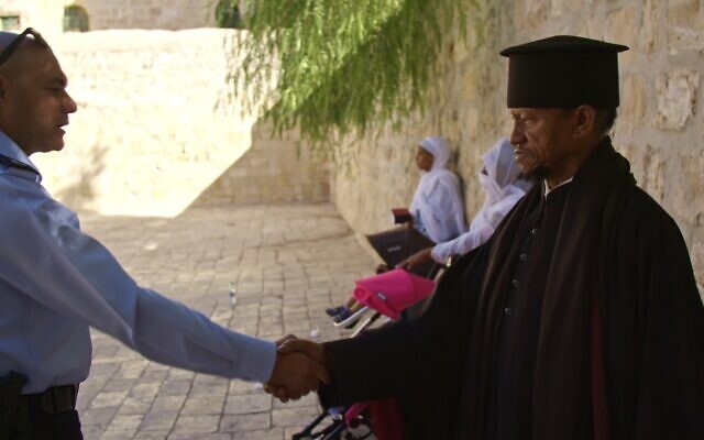 Israel police liaison officer for Christian communities Johnny Kassabri shakes hands with Fr. Zion of the Ethiopian Orthodox Church on the roof of the Church of the Holy Sepulchre. (Yoram Millo)