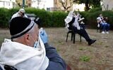Jewish men pray while social distancing outside a closed synagogue in the coastal city of Netanya, April 23, 2020. (Jack Guez/AFP via Getty Images via JTA)