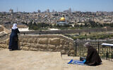 A Muslim woman prays in East Jerusalem's Mount of Olives, overlooking the Dome of the Rock and al-Aqsa mosque compound on the Temple Mount, which remains shut to prevent the spread of coronavirus during the holy month of Ramadan, May 1, 2020. (AP Photo/Ariel Schalit)