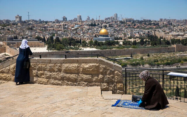 A Muslim woman prays in East Jerusalem's Mount of Olives, overlooking the Dome of the Rock and al-Aqsa mosque compound on the Temple Mount, which remains shut to prevent the spread of coronavirus during the holy month of Ramadan, May 1, 2020. (AP Photo/Ariel Schalit) A Muslim woman prays in East Jerusalem's Mount of Olives, overlooking the Dome of the Rock and al-Aqsa mosque compound on the Temple Mount, which remains shut to prevent the spread of coronavirus during the holy month of Ramadan, May 1, 2020. (AP Photo/Ariel Schalit)