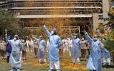 An Indian Air Force helicopter showers flower petals on the staff of INS Asvini hospital in Mumbai, India, Sunday, May 3, 2020. The event was part the Armed Forces' efforts to thank the workers, including doctors, nurses and police personnel, who have been at the forefront of the country's battle against the COVID-19 pandemic. (AP Photo/Rajanish Kakade)