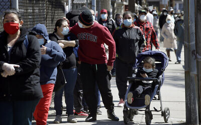 People wear masks out of concern for the coronavirus while standing in line outside a Salvation Army food pantry, May 5, 2020, in Chelsea, Massachusetts. (AP Photo/Steven Senne) People wear masks out of concern for the coronavirus while standing in line outside a Salvation Army food pantry, May 5, 2020, in Chelsea, Massachusetts. (AP Photo/Steven Senne)