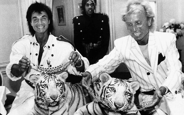 In this June 4, 1987, file photo, Las Vegas magicians Roy Horn, left, and Siegfried Fischbacher pose in New York, with their rare white tigers, Neva, left, a female, and Vegas, a male. Horn, one half of the longtime Las Vegas illusionist duo Siegfried & Roy, died of complications from the coronavirus, Friday, May 8, 2020. He was 75. (AP Photo/Scott McKiernan) In this June 4, 1987, file photo, Las Vegas magicians Roy Horn, left, and Siegfried Fischbacher pose in New York, with their rare white tigers, Neva, left, a female, and Vegas, a male. Horn, one half of the longtime Las Vegas illusionist duo Siegfried & Roy, died of complications from the coronavirus, Friday, May 8, 2020. He was 75. (AP Photo/Scott McKiernan)