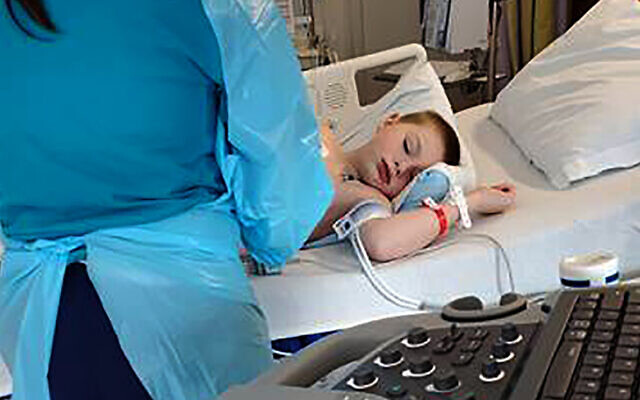 In this 2020 photo provided by Amber Dean, 9-year-old Bobby Dean lies on a hospital bed in Rochester, New York, after being admitted with severe dehydration, abdominal pain and a racing heart. (Dean Family Photo via AP) In this 2020 photo provided by Amber Dean, 9-year-old Bobby Dean lies on a hospital bed in Rochester, New York, after being admitted with severe dehydration, abdominal pain and a racing heart. (Dean Family Photo via AP)