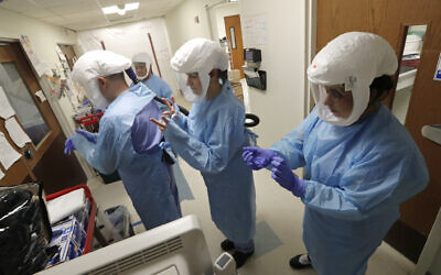 In this May 8, 2020, file photo, a team of medical workers wearing respirators and protective gear ready to enter the room of a patient in the COVID-19 Intensive Care Unit at Harborview Medical Center, in Seattle. (AP/Elaine Thompson, File)