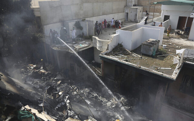 Fire brigade staff try to put out fire caused by plane crash in Karachi, Pakistan, Friday, May 22, 2020. An aviation official says a passenger plane belonging to state-run Pakistan International Airlines carrying more than 100 passengers and crew has crashed near the southern port city of Karachi. There were no immediate reports on the number of casualties. (AP Photo/Fareed Khan) Fire brigade staff try to put out fire caused by plane crash in Karachi, Pakistan, Friday, May 22, 2020. An aviation official says a passenger plane belonging to state-run Pakistan International Airlines carrying more than 100 passengers and crew has crashed near the southern port city of Karachi. There were no immediate reports on the number of casualties. (AP Photo/Fareed Khan)