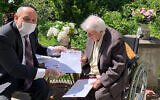 Poland's chief rabbi, Michael Schudrich, delivers letters with birthday greetings from the Israeli and Polish presidents, to Anna Kozminska, a 101-year-old Polish woman who is believed to the be oldest living person recognized by Yad Vashem for rescuing Jews during the Holocaust, in Warsaw, Poland, on Friday, May 22, 2020.  (Grazyna Pawlak via AP)
