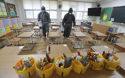 Illustrative: Workers disinfect as a precaution against the new coronavirus ahead of school reopening in a class at an elementary school in Gwangju, South Korea, May 26, 2020. (Park Chul-hong/Yonhap via AP) Illustrative: Workers disinfect as a precaution against the new coronavirus ahead of school reopening in a class at an elementary school in Gwangju, South Korea, May 26, 2020. (Park Chul-hong/Yonhap via AP)