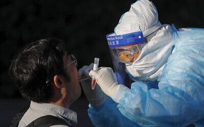 A medical worker takes a swab from a foreign reporter who was selected to cover the closing session of the Chinese People's Political Consultative Conference (CPPCC) for the coronavirus test, at a hotel in Beijing, May 27, 2020. (Andy Wong/AP)