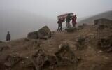 Cemetery workers carry the coffin with the corpse of Flavio Juárez, 50, who died from COVID-19, at the Nueva Esperanza cemetery on the outskirts of Lima, Peru, May 26, 2020. (Rodrigo Abd/AP)