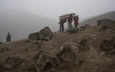 Cemetery workers carry the coffin with the corpse of Flavio Juárez, 50, who died from COVID-19, at the Nueva Esperanza cemetery on the outskirts of Lima, Peru, May 26, 2020. (Rodrigo Abd/AP)