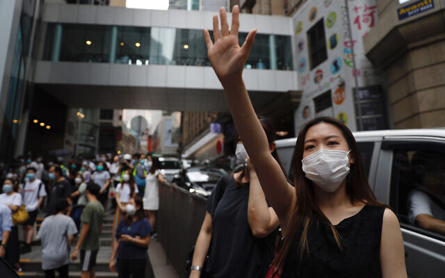 A protester gestures with five fingers, signifying the 'Five demands - not one less' during a protest in Central Government Complex in Hong Kong, May 27, 2020. (AP Photo/Kin Cheung)