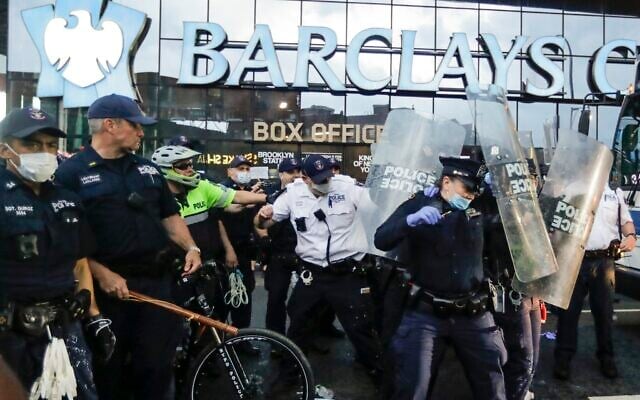 Police officers protect themselves with shields as protesters throw debris during a rally Friday, May 29, 2020, in the Brooklyn borough of New York, at the Barclays Center (AP Photo/Frank Franklin II) Police officers protect themselves with shields as protesters throw debris during a rally Friday, May 29, 2020, in the Brooklyn borough of New York, at the Barclays Center (AP Photo/Frank Franklin II)