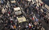 A group of US protesters surrounded several National Guard vehicles that were driving on Lake Street towards the blockade under the Hiawatha Light Rail station and forced them to reverse out in Minneapolis, Minnesota, May 29, 2020. (Renee Jones Schneider/Star Tribune via AP)