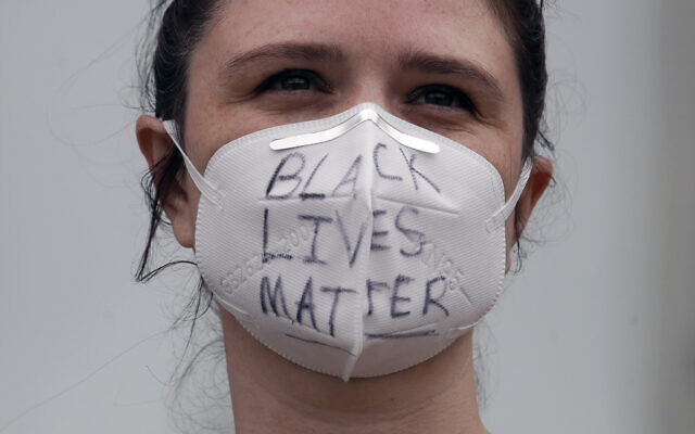 A woman wears a face mask with Black Lives Matter written on it at a protest over the Memorial Day death of George Floyd, a handcuffed black man in police custody in Minneapolis, in San Francisco, Saturday, May 30, 2020. (AP Photo/Jeff Chiu) A woman wears a face mask with Black Lives Matter written on it at a protest over the Memorial Day death of George Floyd, a handcuffed black man in police custody in Minneapolis, in San Francisco, Saturday, May 30, 2020. (AP Photo/Jeff Chiu)