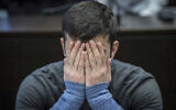 22-year-old Ali Bashar covers his face as he arrives at a court in Wiesbaden, Germany, March 12, 2019. (Boris Roessler/dpa via AP, Pool)