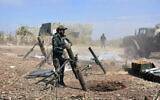 Illustrative: Syrian army soldiers prepare to launch a mortar towards insurgents in the village of Kfar Nabuda, in the countryside of Hama province on May 11, 2019. (SANA via AP)