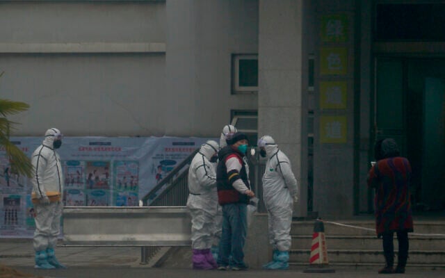 Staff in biohazard suits hold a metal stretcher by the in-patient department of Wuhan Medical Treatment Center, where some infected with a novel coronavirus are being treated, in Wuhan, China, Tuesday, Jan. 21, 2020. (AP Photo/Dake Kang) Staff in biohazard suits hold a metal stretcher by the in-patient department of Wuhan Medical Treatment Center, where some infected with a novel coronavirus are being treated, in Wuhan, China, Tuesday, Jan. 21, 2020. (AP Photo/Dake Kang)
