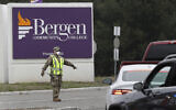 A member of the New Jersey National Guard directs traffic at the entrance to a drive-thru COVID-19 testing center in Paramus, N.J., Friday, March 20, 2020. The facility opened Friday in Bergen County which has been the state's hardest-hit area.  (AP Photo/Seth Wenig)