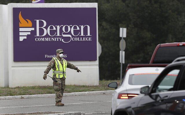 A member of the New Jersey National Guard directs traffic at the entrance to a drive-thru COVID-19 testing center in Paramus, N.J., Friday, March 20, 2020. The facility opened Friday in Bergen County which has been the state's hardest-hit area. (AP Photo/Seth Wenig) A member of the New Jersey National Guard directs traffic at the entrance to a drive-thru COVID-19 testing center in Paramus, N.J., Friday, March 20, 2020. The facility opened Friday in Bergen County which has been the state's hardest-hit area. (AP Photo/Seth Wenig)