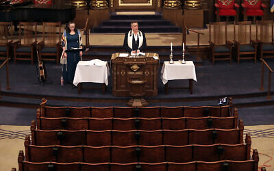 Illustrative: Rodef Shalom Rabbi Aaron Bisno, center, delivers his sermon with soloist Molly May, left, during an Erev Shabbat service that is being streamed live on Facebook, Friday, March 20, 2020.(AP Photo/Gene J. Puskar)