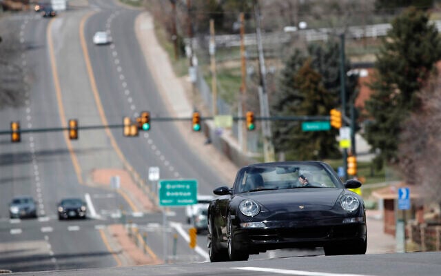 A motorist guides his Porsche convertible along a nearly-empty South University Boulevard, April 5, 2020, in Cherry Hills Village, Colo. (AP/David Zalubowski) A motorist guides his Porsche convertible along a nearly-empty South University Boulevard, April 5, 2020, in Cherry Hills Village, Colo. (AP/David Zalubowski)
