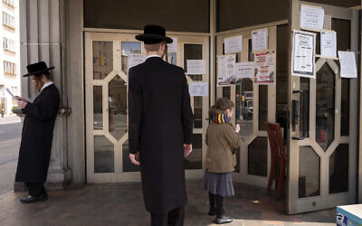 A man stops to read an announcement at Congregation Divrei Yoel in the Williamsburg neighborhood of Brooklyn, Tuesday, April 7, 2020 in New York. The synagogue is closed to gatherings due to the coronavirus. (AP/Mark Lennihan)