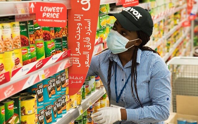 In this April 19, 2020 photo, Vox Cinema employee Jackline Nansamba of Uganda stocks shelves at a Carrefour supermarket while wearing a face mask amid the coronavirus pandemic in Dubai, United Arab Emirates. (AP Photo/Jon Gambrell) In this April 19, 2020 photo, Vox Cinema employee Jackline Nansamba of Uganda stocks shelves at a Carrefour supermarket while wearing a face mask amid the coronavirus pandemic in Dubai, United Arab Emirates. (AP Photo/Jon Gambrell)