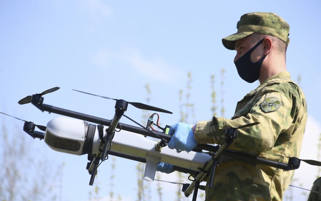 In this photo taken on May 3, 2020, A Russian Rosguardia (National Guard) soldier prepares to launch a drone in Moscow in Losiny Ostrov (Elk Island) national park in northeastern, Russia. Police in Moscow said they would use helicopters and drones to monitor violations of a lockdown intended to stem the spread of the new coronavirus. Russian officials are reporting a steady rise in the number of the new coronavirus infections that raises pressure on the nation's health care system. (Sergey Vedyashkin, Moscow News Agency photo via AP)