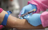 A health worker draws blood from a patient for a COVID-19 antibody test at the Volusia County Fairgrounds in DeLand, Florida, on May 5, 2020. (AP Photo/John Raoux)