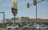 Cars drive by a McDonald's restaurant Thursday, May 7, 2020, in Oklahoma City, where three McDonald's employees suffered gunshot wounds when a customer opened fire because she was angry that the restaurant's dining area was closed because of the coronavirus pandemic, on Wednesday. (AP Photo/Sue Ogrocki)