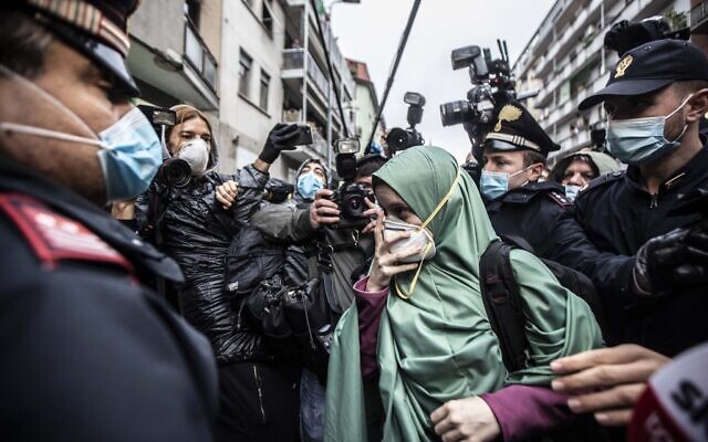 Silvia Romano, escorted by Carabinieri officers, arrives at her home wearing the green hijab typical of Somali Muslim women and a surgical mask to guard against COVID-19, in Milan, Italy, May 11, 2020. (AP Photo/Luca Bruno, File ) Silvia Romano, escorted by Carabinieri officers, arrives at her home wearing the green hijab typical of Somali Muslim women and a surgical mask to guard against COVID-19, in Milan, Italy, May 11, 2020. (AP Photo/Luca Bruno, File )