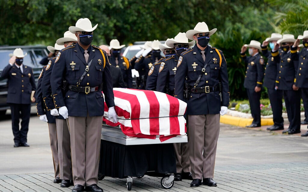 Members of the Harris County Sheriff's Honor Guard move the casket of Sgt. Raymond Scholwinski, who died after contracting COVID-19, during a funeral service, May 14, 2020, in Humble, Texas. (AP Photo/David J. Phillip) Members of the Harris County Sheriff's Honor Guard move the casket of Sgt. Raymond Scholwinski, who died after contracting COVID-19, during a funeral service, May 14, 2020, in Humble, Texas. (AP Photo/David J. Phillip)