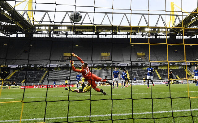 Dortmund's Raphael Guerreiro scores his side's 4th goal against Schalke's goalkeeper Markus Schubert during the German Bundesliga soccer match between Borussia Dortmund and Schalke 04 in Dortmund, Germany, Saturday, May 16, 2020. (AP/Martin Meissner, Pool) Dortmund's Raphael Guerreiro scores his side's 4th goal against Schalke's goalkeeper Markus Schubert during the German Bundesliga soccer match between Borussia Dortmund and Schalke 04 in Dortmund, Germany, Saturday, May 16, 2020. (AP/Martin Meissner, Pool)