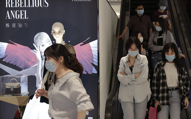 People wearing protective face masks to help curb the spread of the new coronavirus ride an escalator at a shopping mall in Beijing, May 17, 2020. (Andy Wong/AP) People wearing protective face masks to help curb the spread of the new coronavirus ride an escalator at a shopping mall in Beijing, May 17, 2020. (Andy Wong/AP)